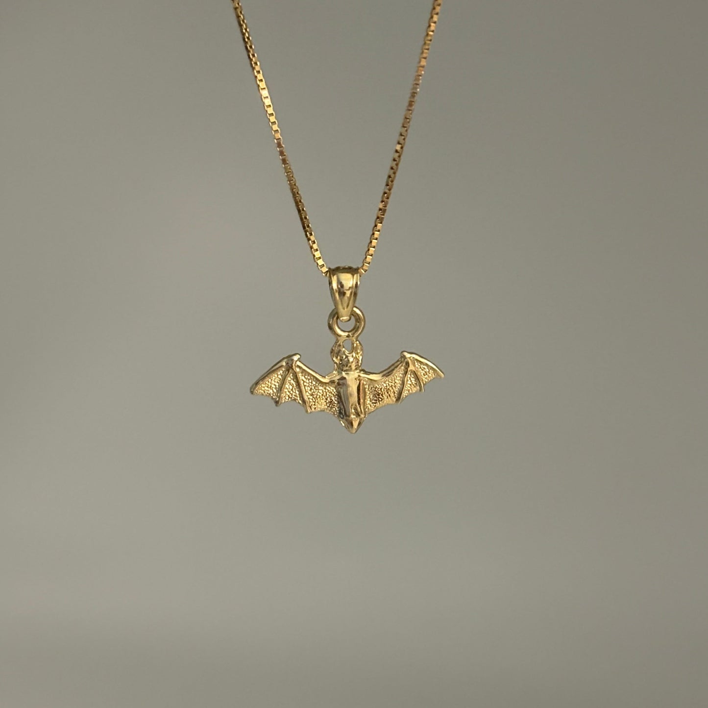 14K gold bat charm pendant with outstretched wings on chain