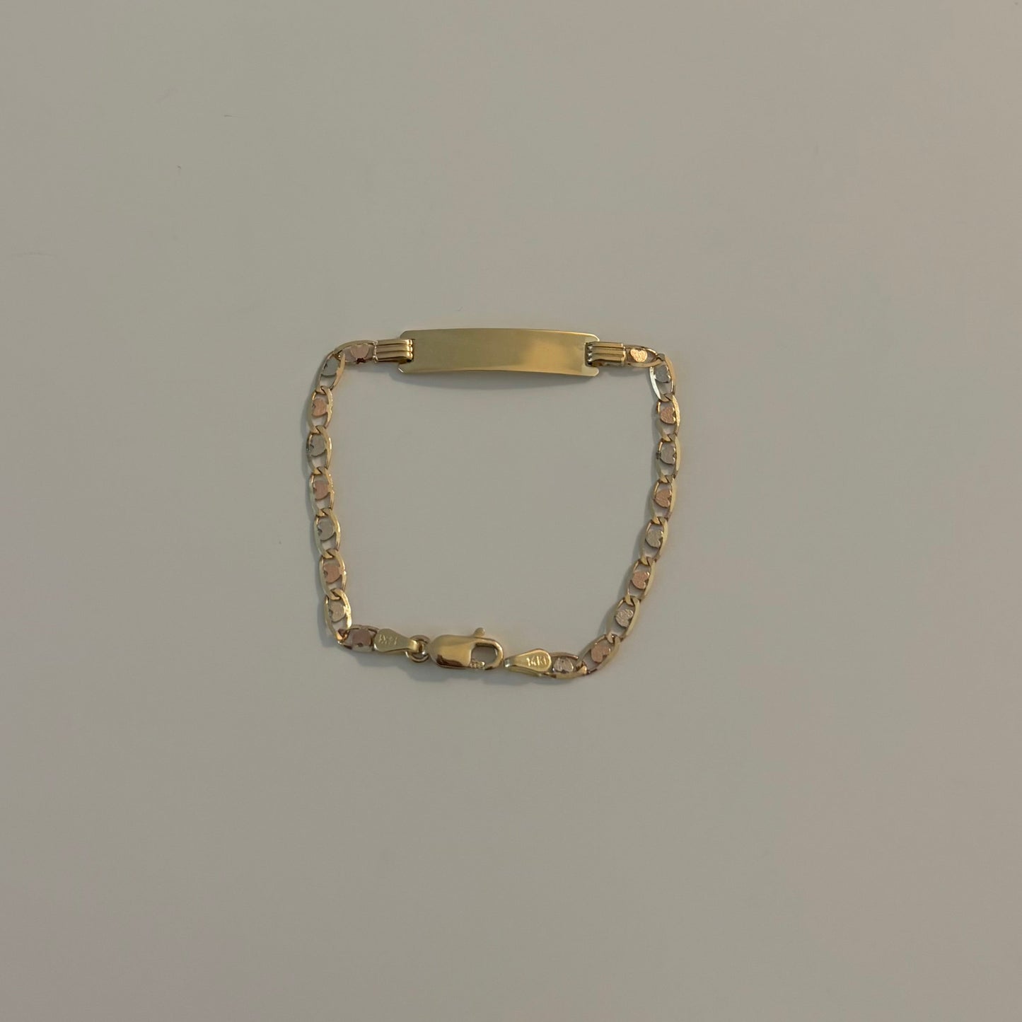 Gold bracelet on a light gray surface
