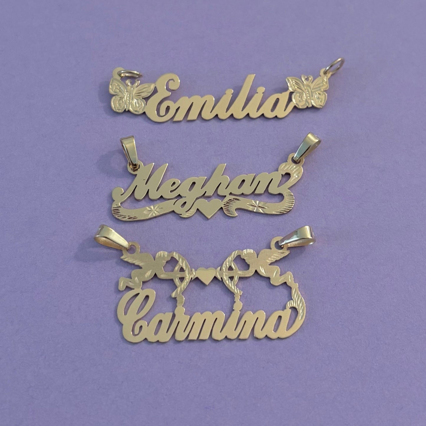 Gold name pendants on a purple surface