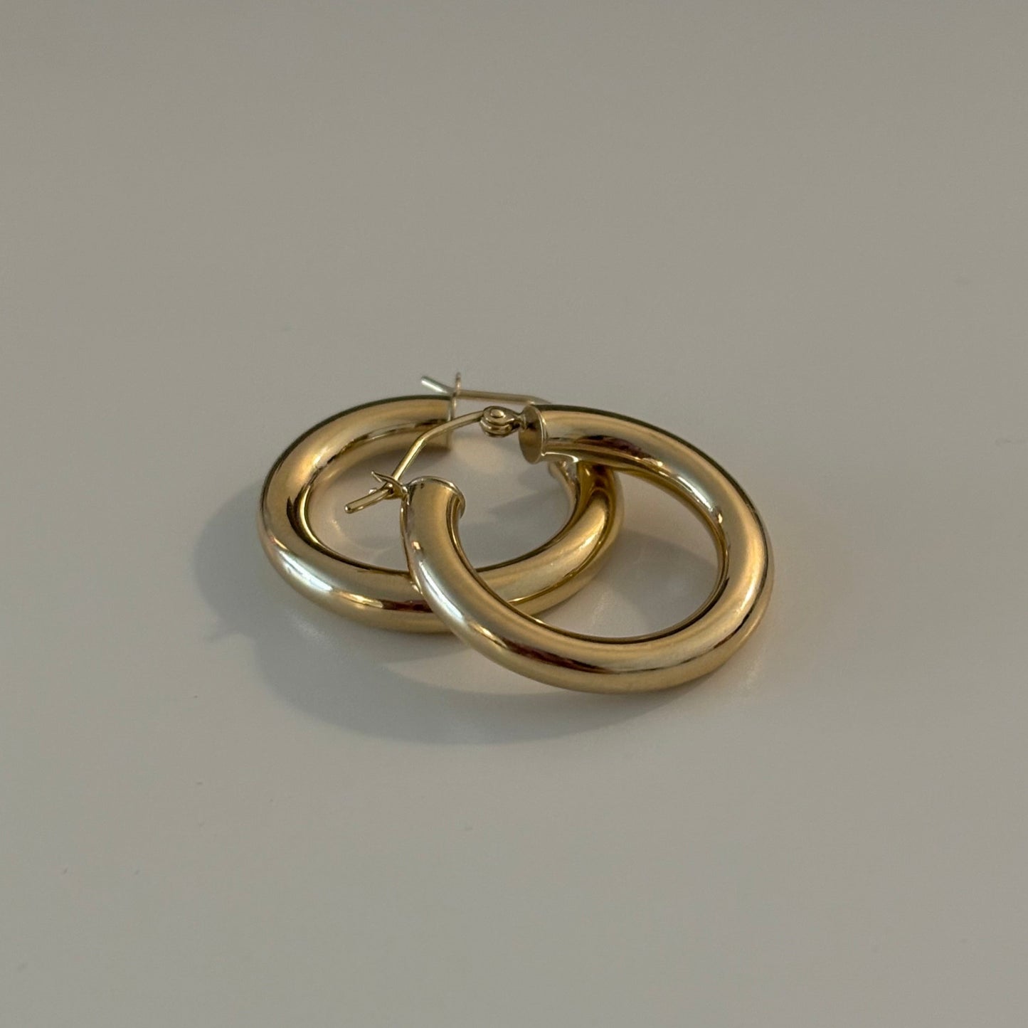 Pair of gold hoop earrings on a light gray background