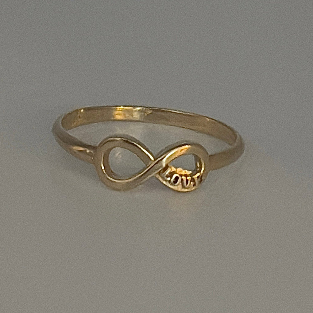 Gold ring with a unique design on a gray background