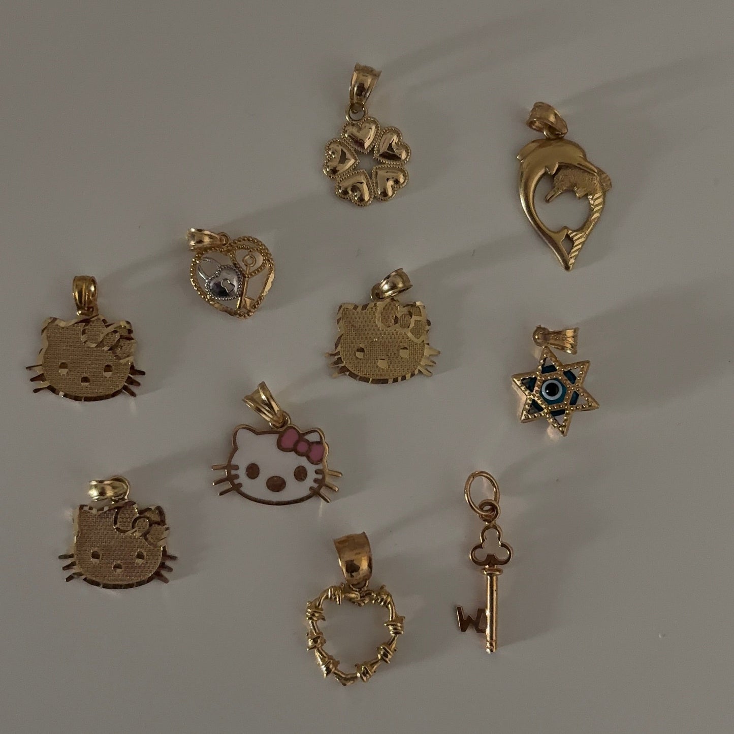 Collection of various gold pendants on a gray background