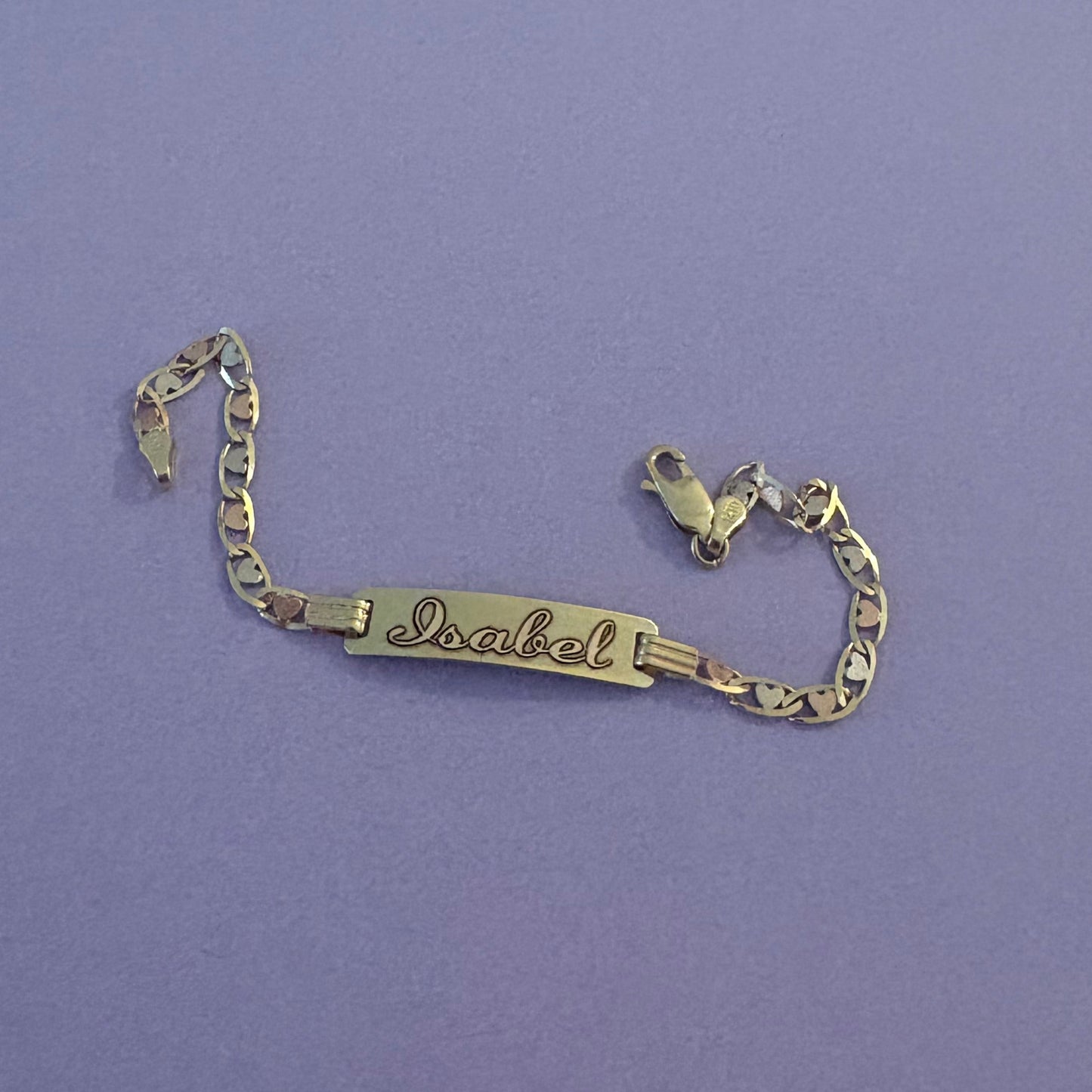Gold bracelet on a purple surface