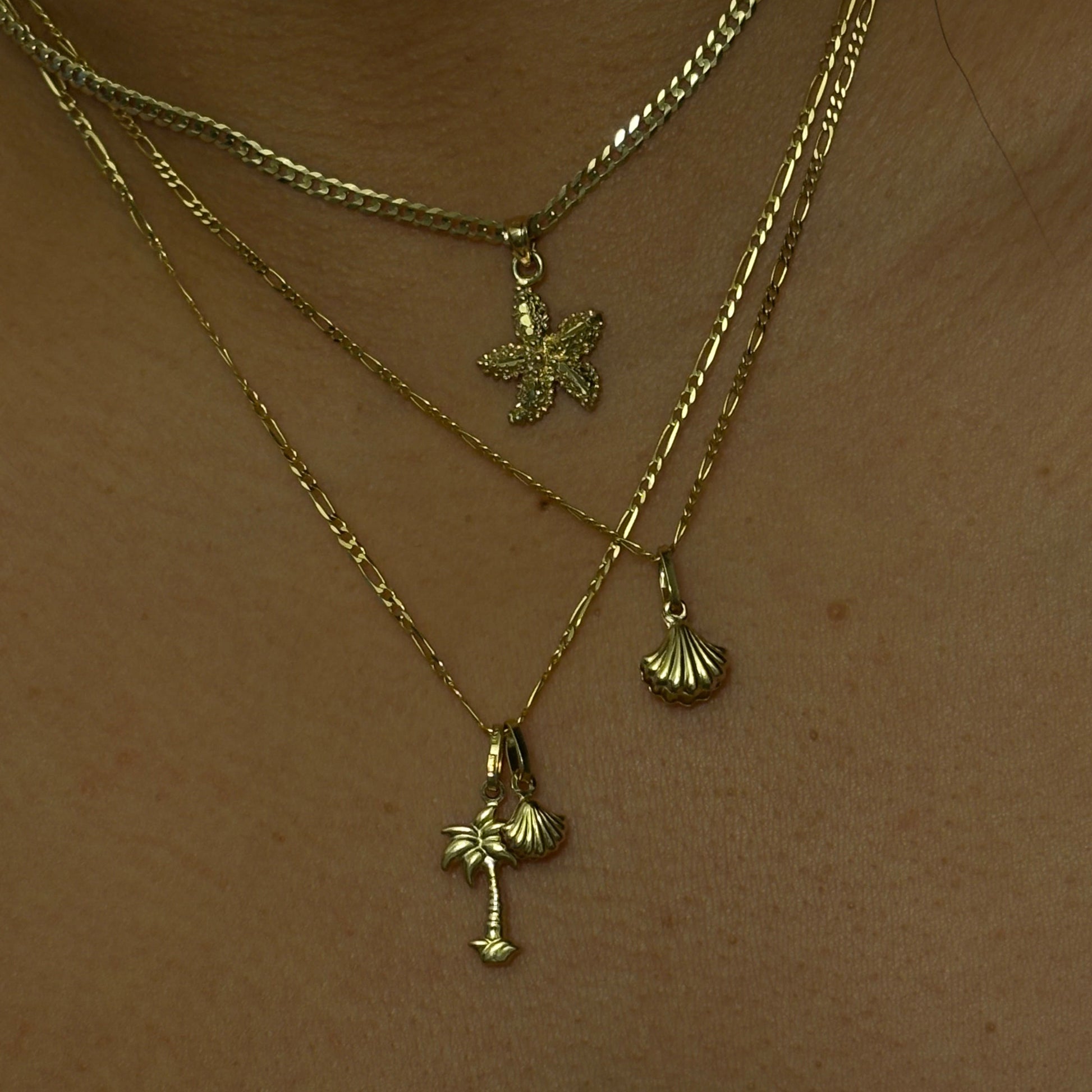 Gold necklace with floral pendants on a wooden surface
