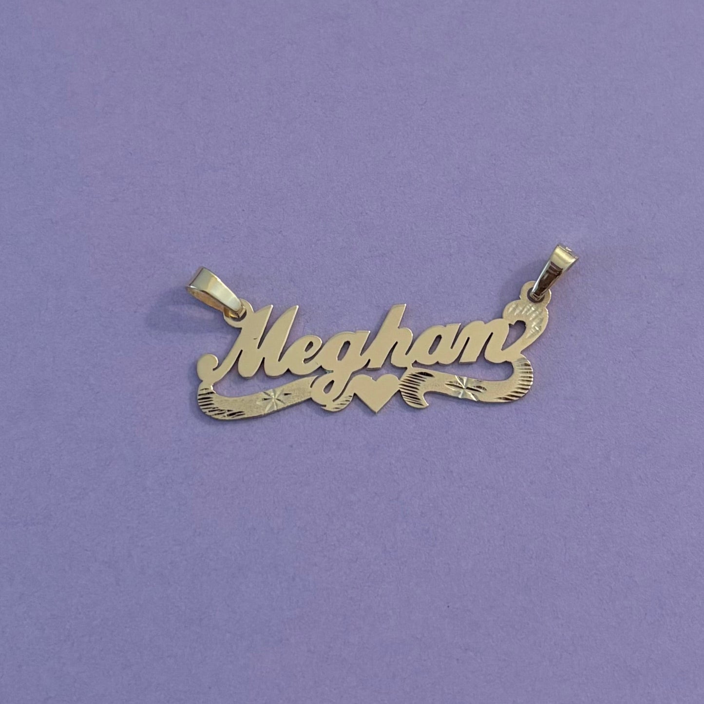 Gold name pendants with heart on a purple background