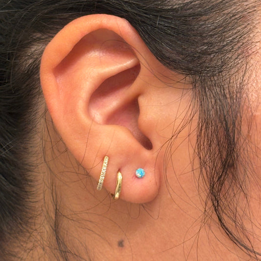 Close-up of an ear with earrings and a ring.