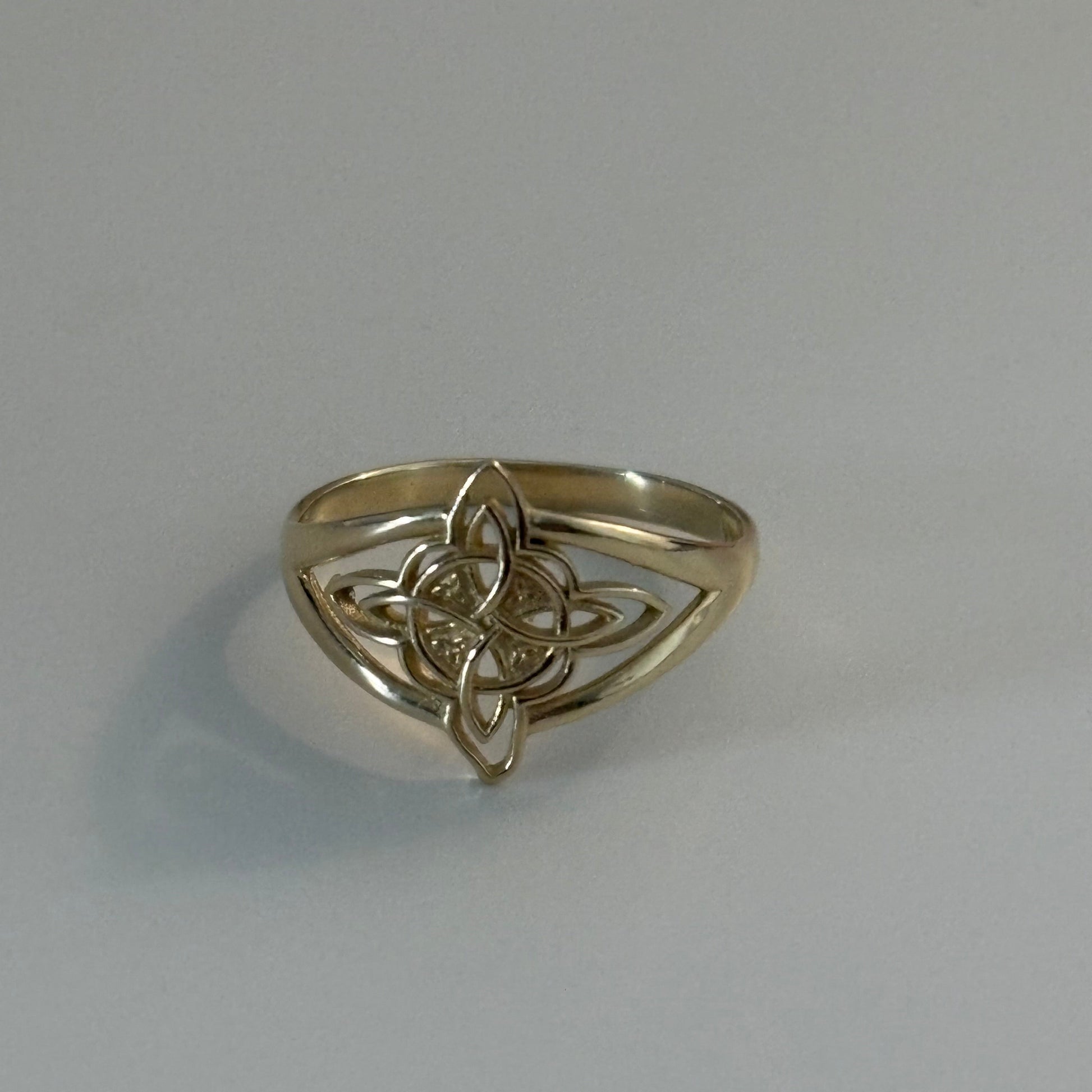 Silver ring with Celtic knot design on a gray background