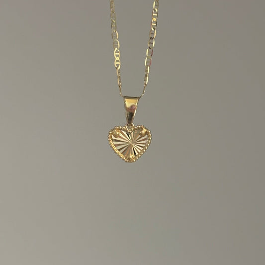 Gold heart-shaped pendant necklace on a gray background
