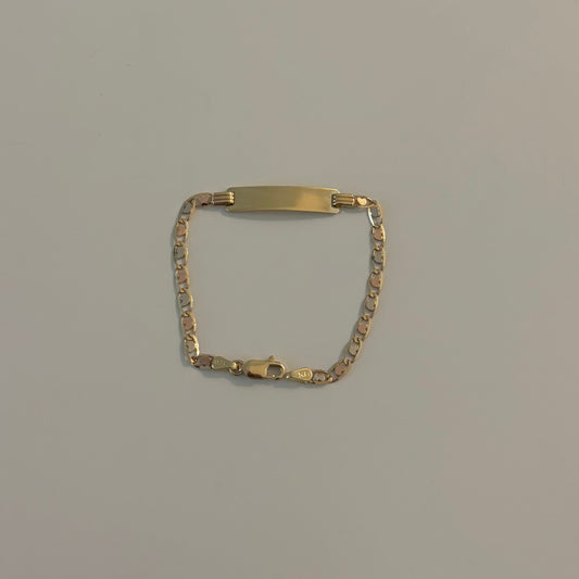 Gold bracelet on a light gray surface
