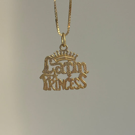 Gold necklace with 'latin Princess' pendant on a gray background
