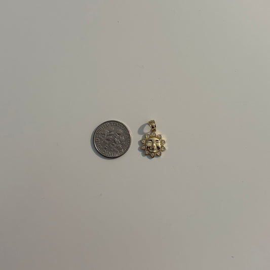 sun charm and coin on a light gray background