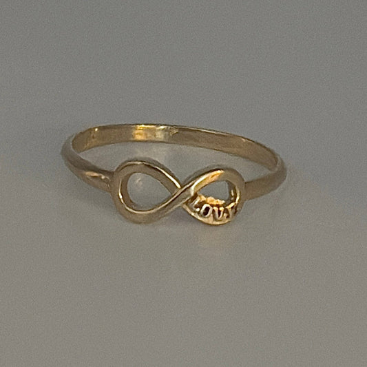 Gold ring with a unique design on a gray background