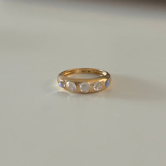 Gold ring with gemstones on a white surface
