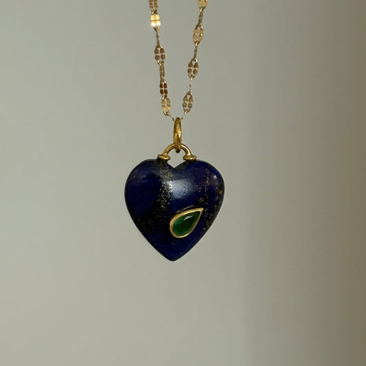 Navy heart-shaped pendant with gold chain on a gray background