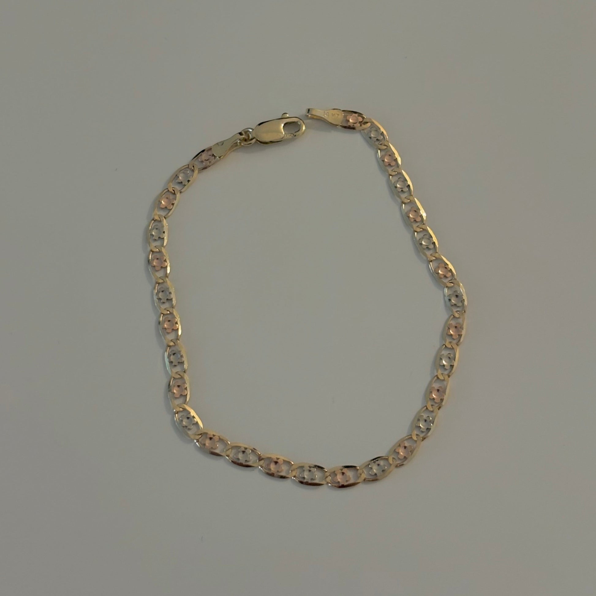 Gold flower chain bracelet on a gray background