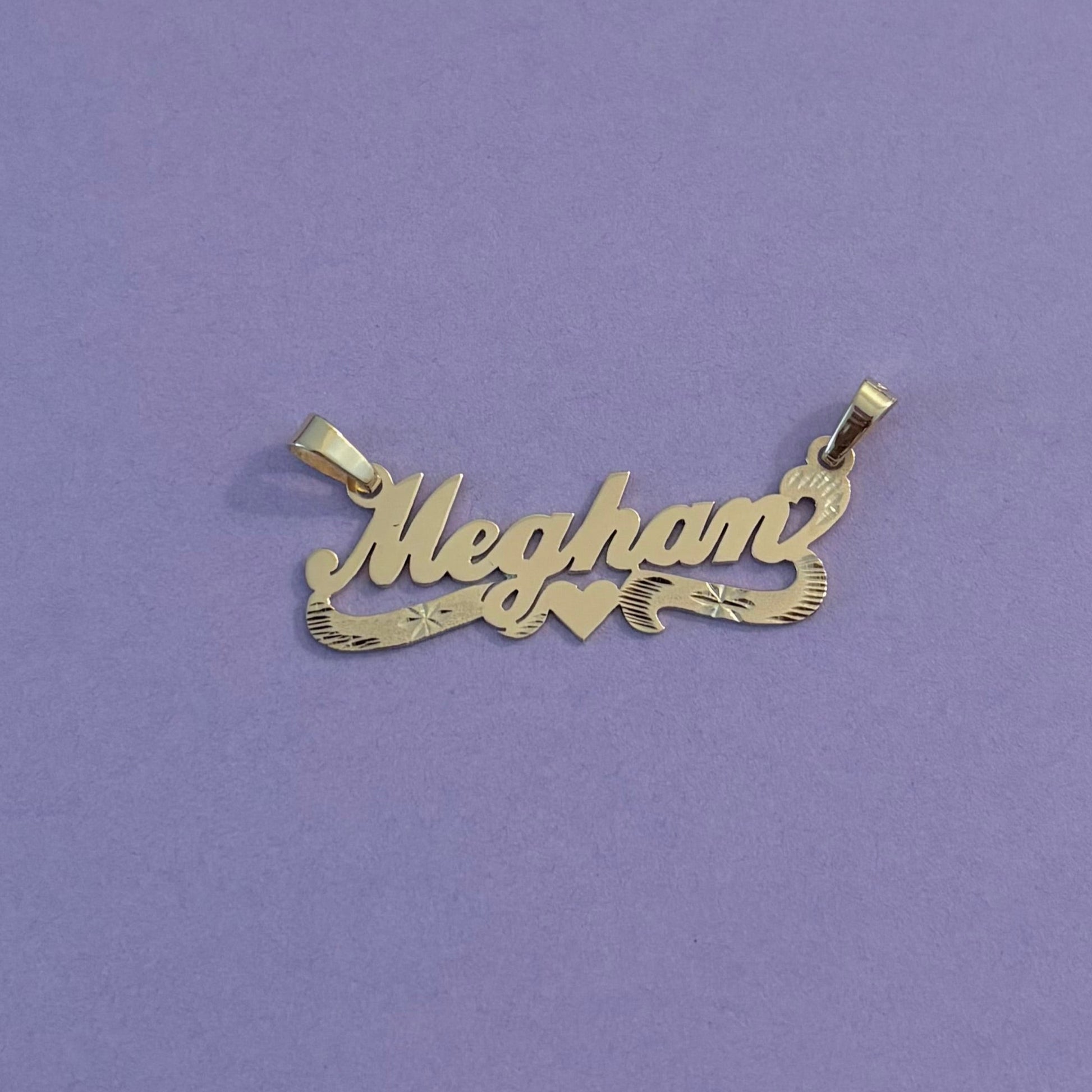 Gold name pendants with heart  on a purple background 
