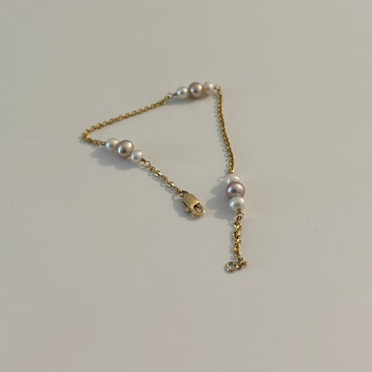 Gold chain with pearls on a white surface