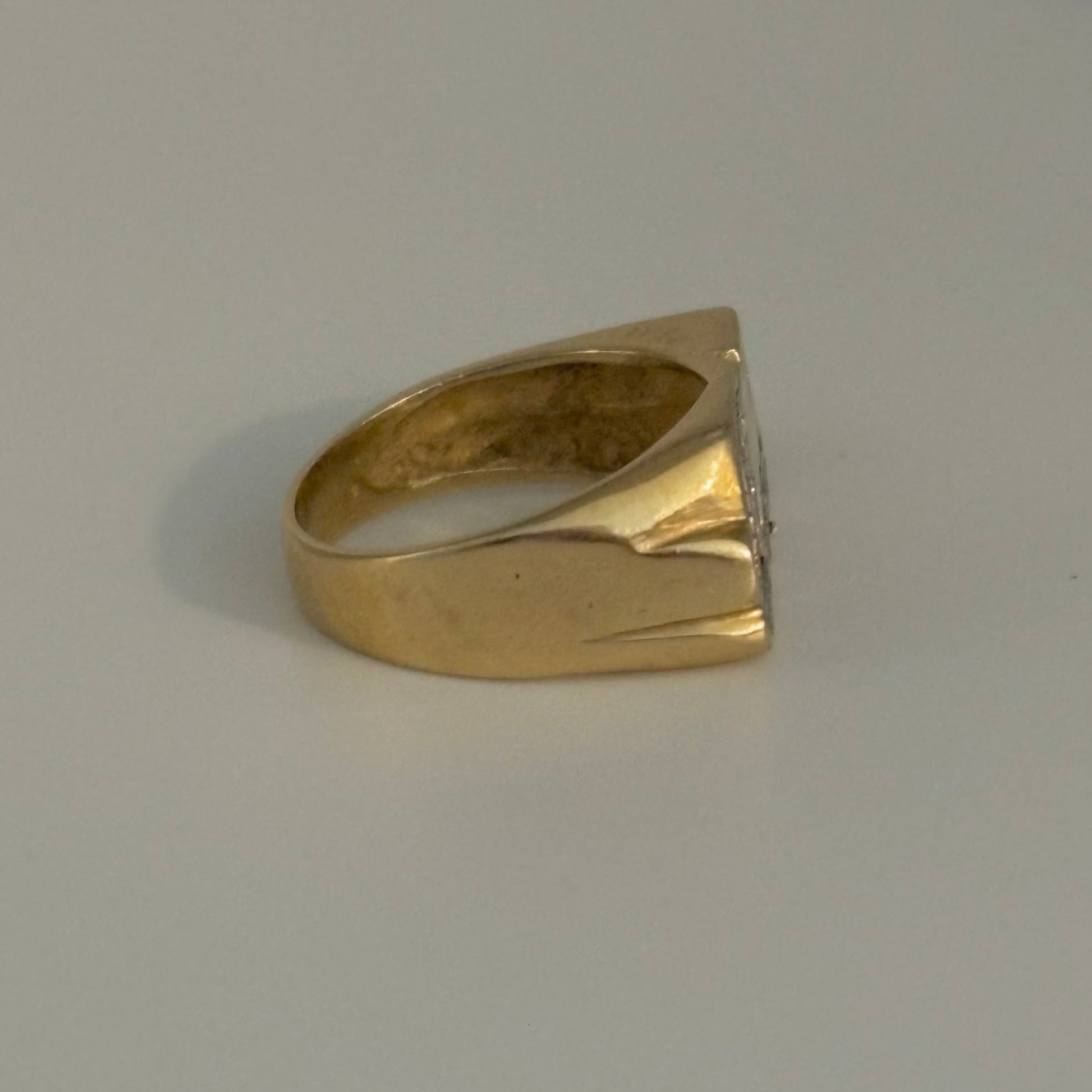 Gold ring with a diamond on a gray background