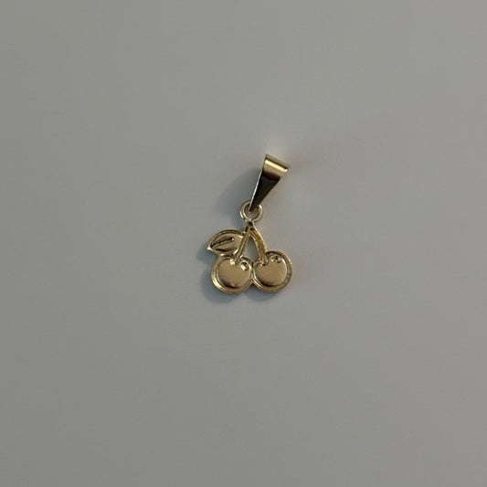 Gold cherry-shaped pendant on a gray background